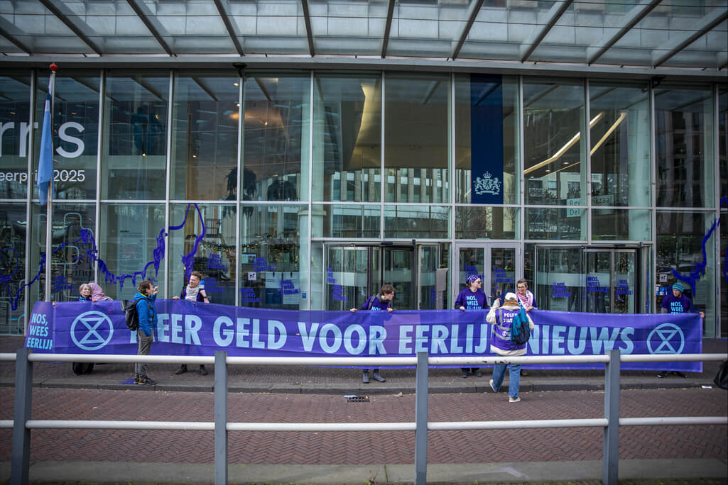 Rebellen met een banner met de tekst “Meer Geld Voor Eerlijk Nieuws”.